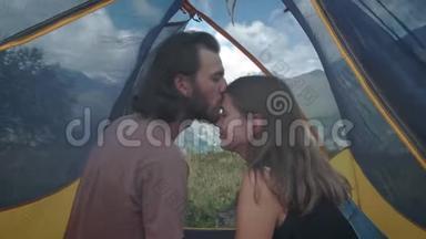 几个男女旅行者在帐篷里接吻。 蜜月野营旅行。 一种浪漫的消遣。 历险记